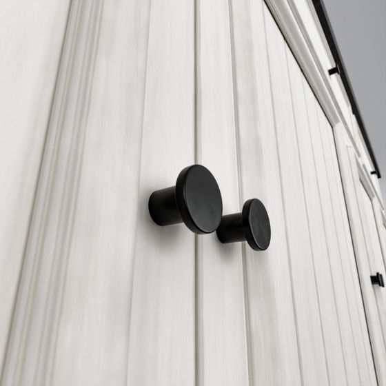 Dos pomos de Fabricados LMG en negro montados en la puerta de un mueble